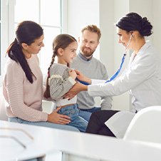 Junge Familie bei Arztbesuch, Ärztin hört die kleine Tochter ab